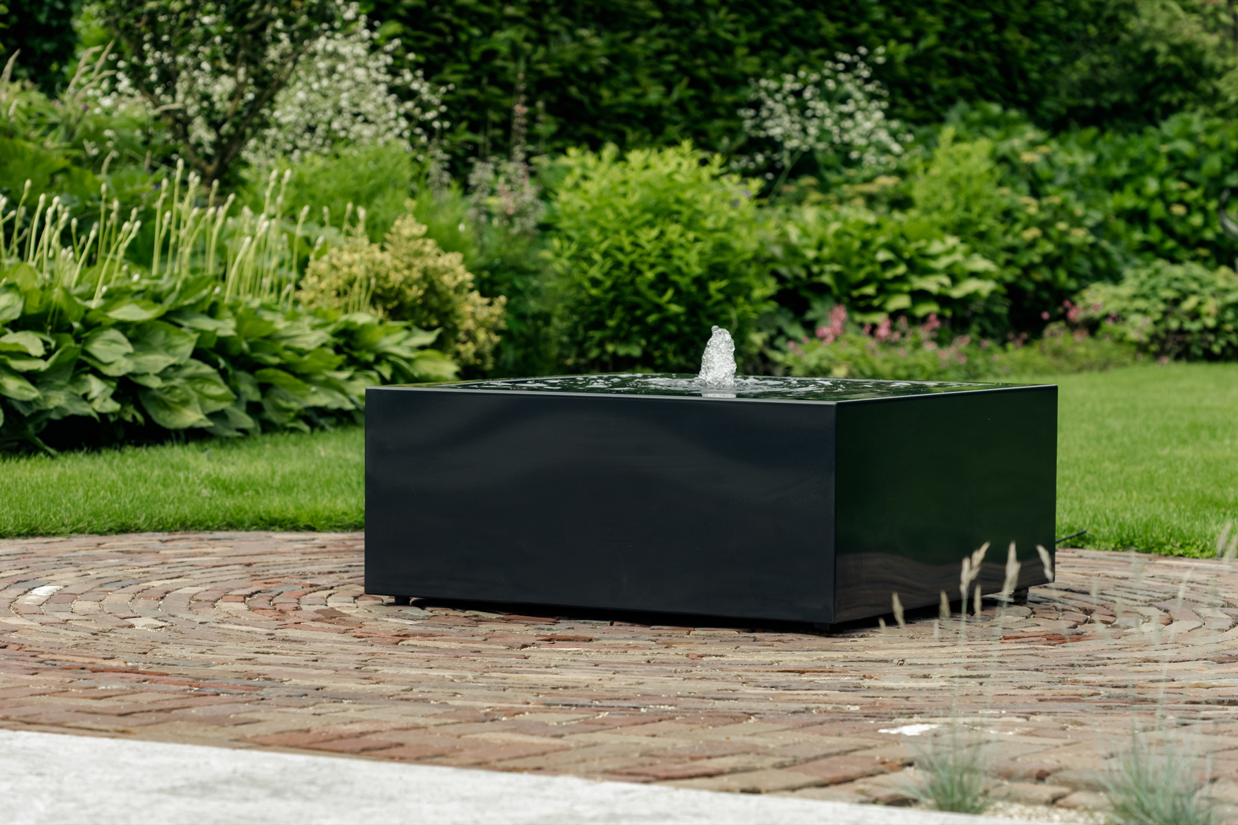 Deze antraciet gepoedercoate aluminium waterbak geeft deze tuin een modern karakter.